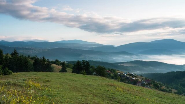 Time lapse with playful, fast-moving morning mists over the tree-covered mountain slopes and the villages nestled in them, Rhodope mountains in Bulgaria