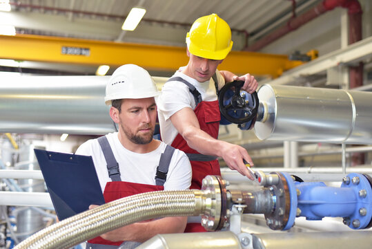 Mechanics repair a machine in a modern industrial plant - profession and teamwork