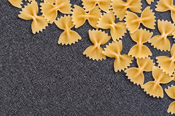 Farfalle or bow tie pasta on black background. Cook background. Italian cuisine. Copy space. Template. Mockup