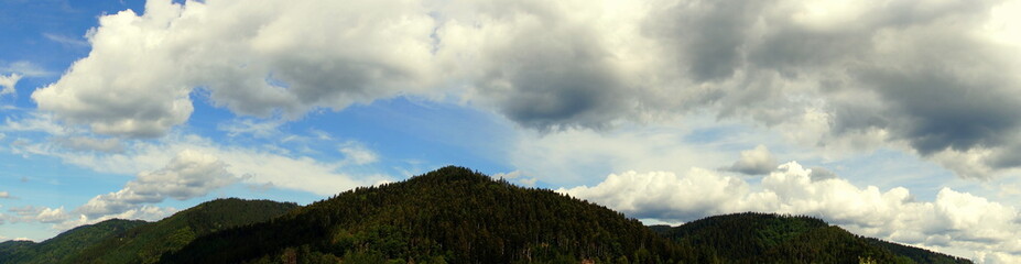 weites Panorama von großen Gewitterwolken über den Schwarzwaldbergen 