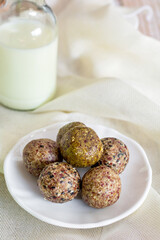 Healthy snack. Energy ball with date plum, black and white sesame, chia and currant in ceramic plate on table. Vegan vegetarian.