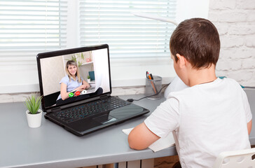 Boy is having a video lesson conference laptop with a teacher at home