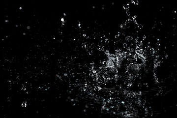 Splashes and drops of water are on a black background.