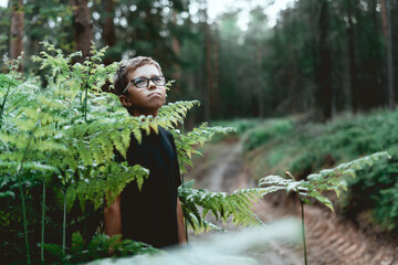 Portrait of a thoughtful young teenager boy In the forest.  