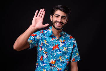 Naklejka premium Young handsome bearded Persian tourist man ready for vacation against black background