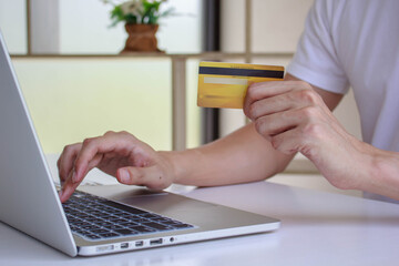 Fototapeta premium Hands holding smart phone and using laptop. Online shopping concept.