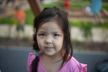 Portrait of a little girl. Asian girl on the street.