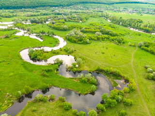 Fototapeta na wymiar aerial drone landscape of river in green field, top view of beautiful nature texture from drone