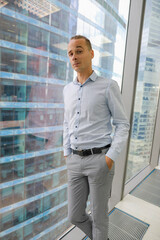 a young man stands at the window in the office