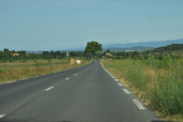 En roulant, route d&eacute;partementale rectiligne dans l'Aude, Languedoc, Occitanie, France.