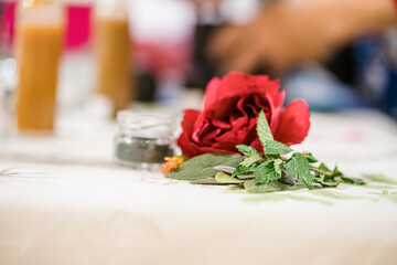 Hands of woman grinding black pepper by pestle in a gray granite mortar on the table.