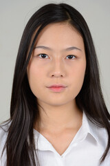 Fototapeta premium Portrait of young beautiful Asian businesswoman against white background