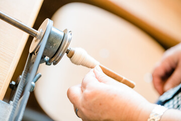 Close up of gold silk weaving on loom, cotton on the manual wood loom in Asian traditional culture and woman hand weave lifestyle