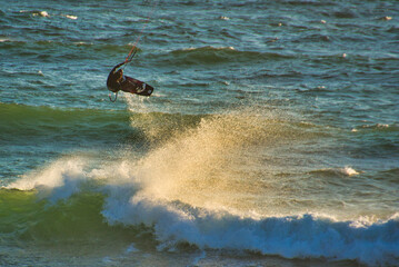 Fototapeta premium Kite surfer in the waves on Blouberg Beach, Western Cape, South Africa