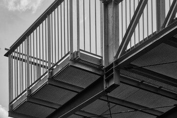 Abstract close-up of a floor grid and a steel railing as platform for a skywalk, black and white