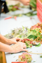 Florist at work: woman making rose hip and hawthorn wreath