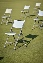 Chairs on the turf of a soccer field maintaining the social distance imposed by corona virus restrictions during an event