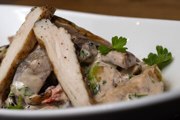 Warm salad with meat slicing in a white plate. Restaurant dishes. Meat salad, not vegans, chicken