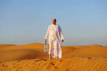 Portrait of thirsty Arabic man on a middle of yellow desert.
