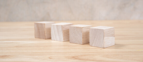 Wooden toy cubes on wooden table ang grey background