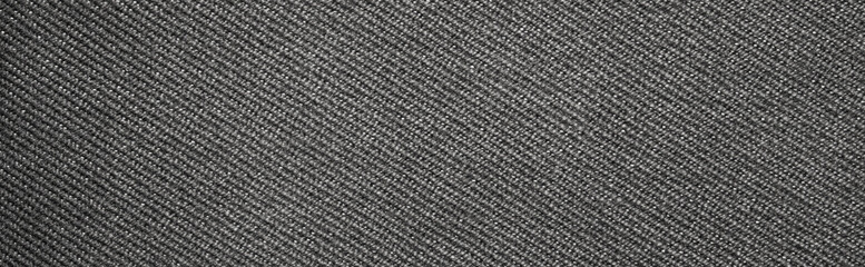 The texture of dark gray fabric is fluted in stripes.Background of dense gray fabric.