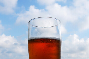glass with beer on the background of a light sky