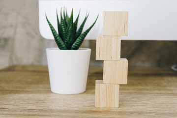 Four wooden toy cubes on wooden table background with copy space