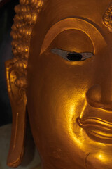 Half front side of Buddha Statue,with full of kindness eyes,old from long life time,gold color