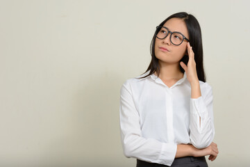 Portrait of young beautiful Asian businesswoman against white background