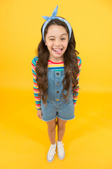 Fun lifestyle little girl long hair denim overalls, cheerful grimace concept