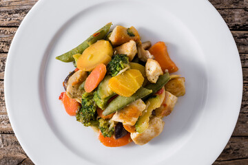 Stir fry chicken with vegetables on wooden table. Top view