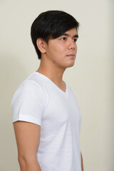 Obraz premium Portrait of young handsome Asian man against white background