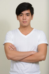 Obraz premium Portrait of young handsome Asian man against white background