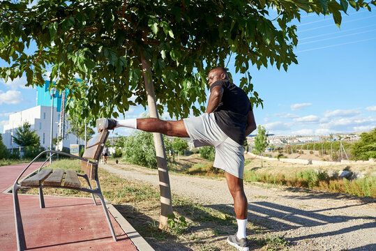 African athlete stretching a sunny summer day.