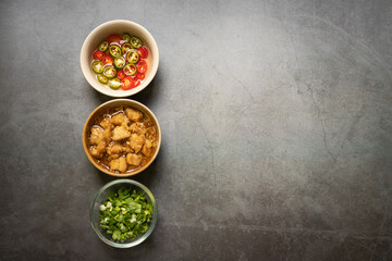 Garlic cracklings with lard, pickled chili, and coriander with spring onion various ingredients and condiment on table for noodles menu. Copy space for your text.