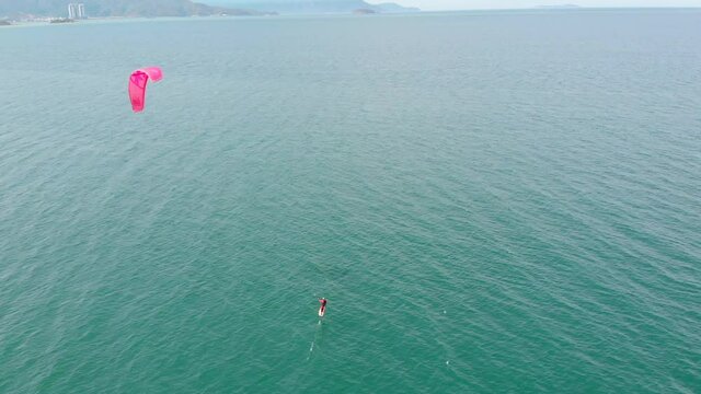 Kite surfing place, sports concept, healthy lifestyle, human flight. Aerial view of the city beach and active people practicing kite surfing and windsurfing.