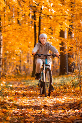 Fototapeta na wymiar Boy riding bicycle in autumn park