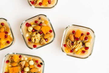 Traditional Turkish Dessert Ashura or Noah's Pudding in square glass bowls on white background,top view