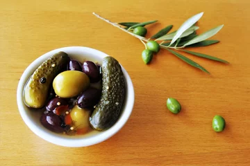 Foto op Plexiglas Pickled cucumbers and pickled olives on the bowl with green olives in the branch beside the bowl.photo  © SOMKHANAsk3