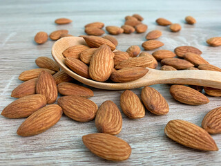 almonds on wooden table, almond on wooden spoon.