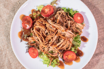 Freshly cooked delicious ripped pork on a wooden tray