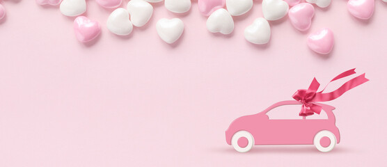 Pink car with gift bow on a pink background with hearts