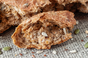 Uneven piece of multigrain bread, whole pumpkin seed, sunflower and flax seeds