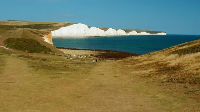 Slow motion walk towards the impressive Seven Sisters, an iconic chalk cliff formation opposite Cuckmere Haven, Sussex, England, UK