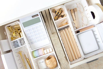 Female white workplace. A method for storing stationery neatly. Stylish gold pens, stapler, glasses, pencils.