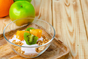 Bowl of granola with youghurt and sliced fruits