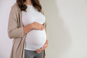 Portrait shot of young beautiful woman on third trimester of pregnancy. Close up of pregnant female...