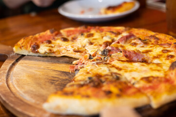 Close up pizza on woodden plate.