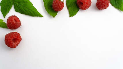 Many ripe raspberries isolated on white background close-up. Beautiful red fresh raspberries with leaves along the contour on the table. Top view. Banner for web site. Free space for text in the right