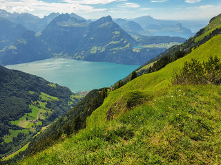 Widok na alpejskie jeziora otoczone wysokimi ośnieżonymi szczytami - obrazy, fototapety, plakaty